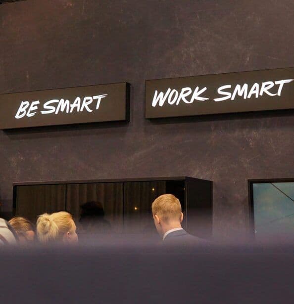 Schilder „Be smart“ und „Work smart“ über dem Stand