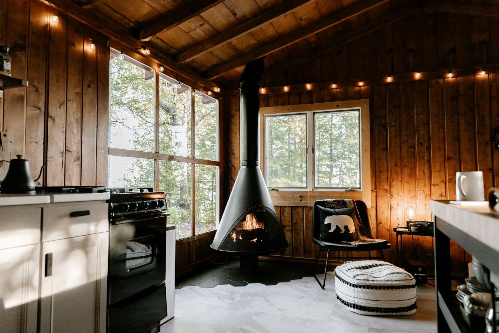 Holzhütte innen mit Kaminofen, Sessel und Lichterkette